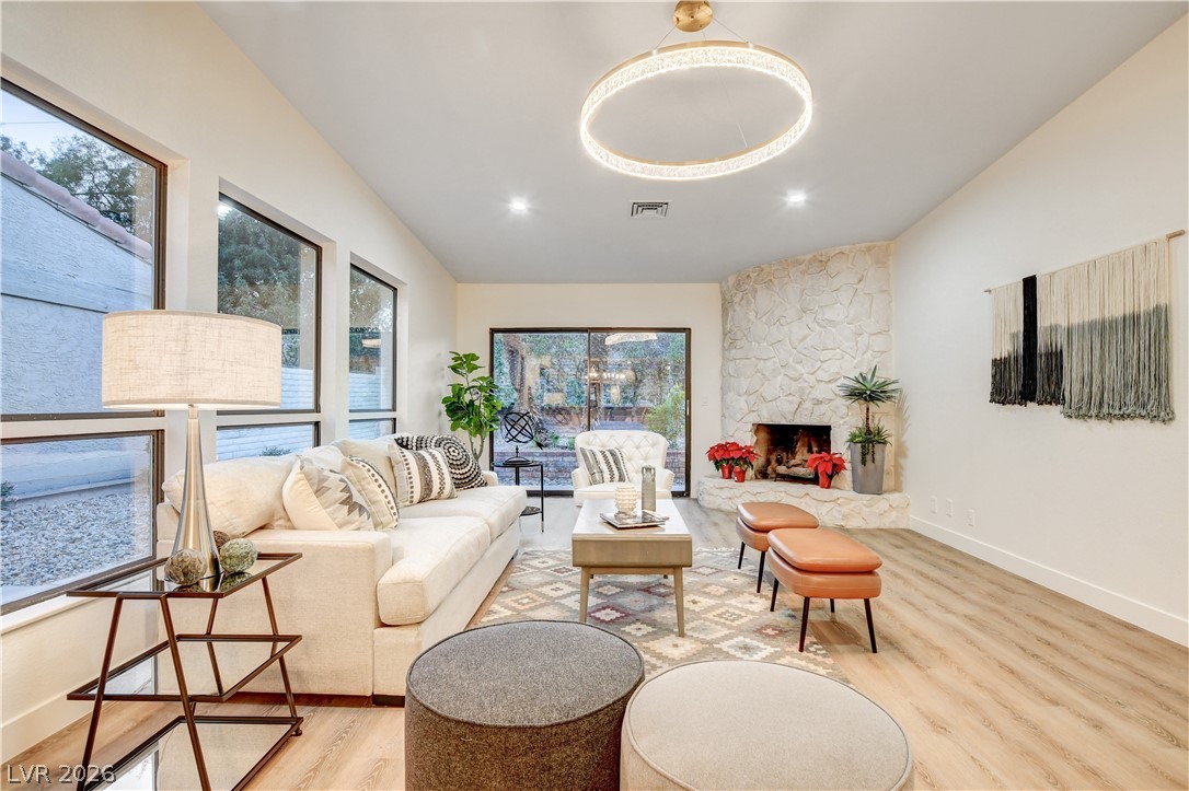 Living room with a cream sectional, large windows, and a floor-to-ceiling stone fireplace.