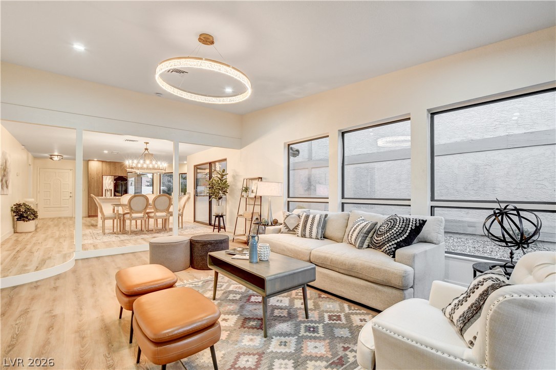 Furnished living room with a cream sectional, patterned rug, and dining area beyond.
