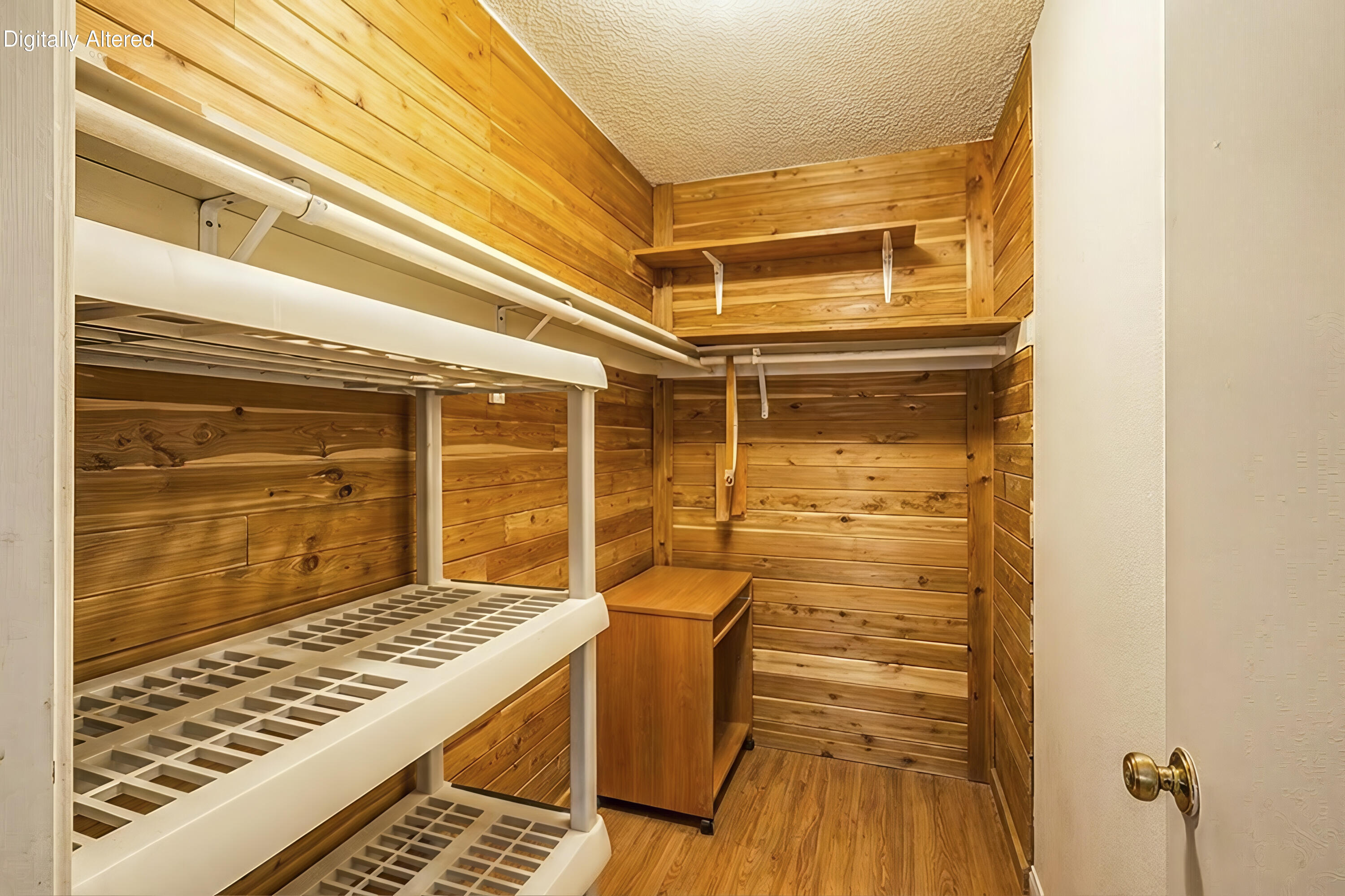 Wood-paneled walk-in closet with white open shelving and a small wooden cabinet.