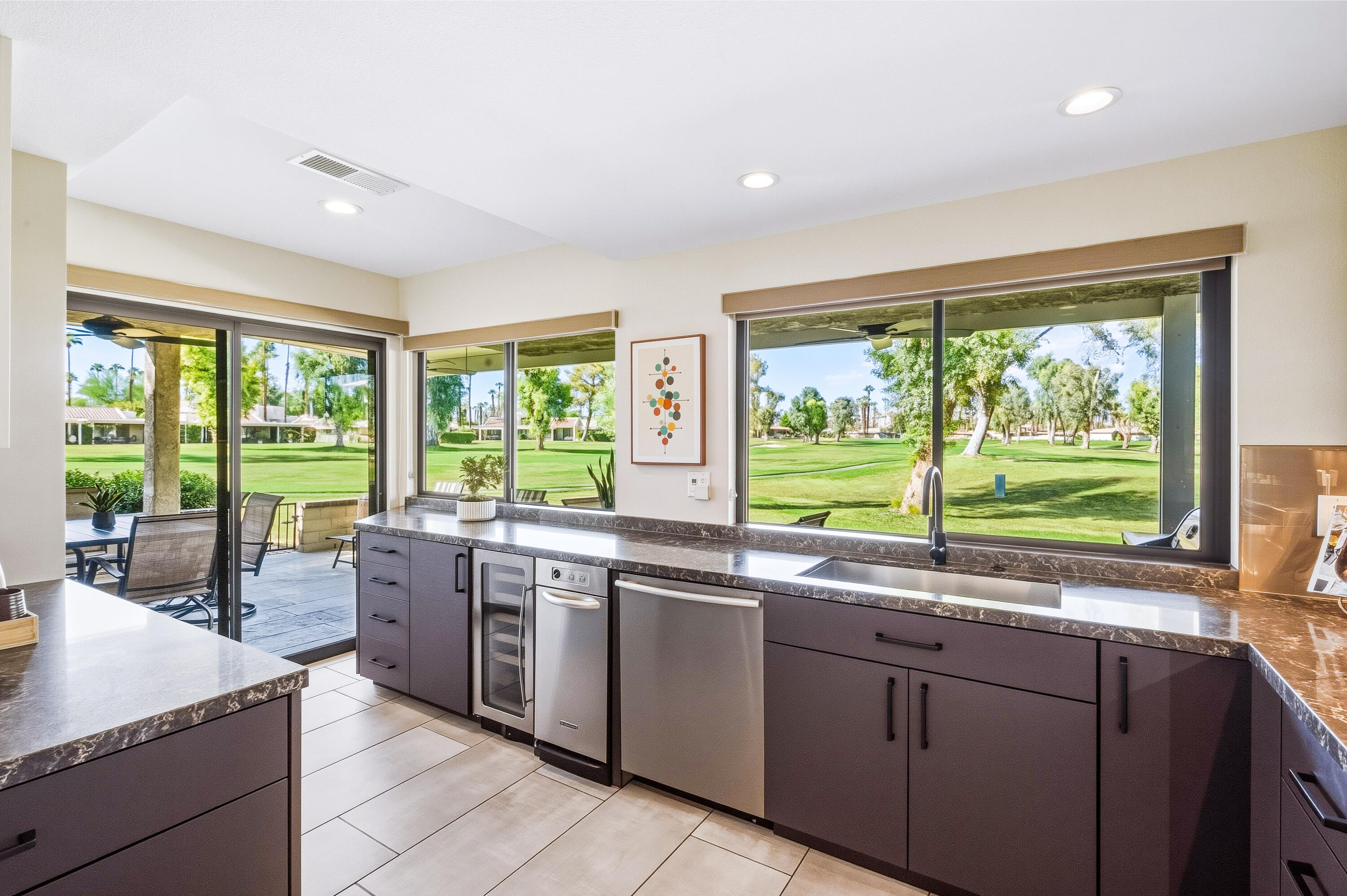 Kitchen with dark cabinets and wide windows overlooking a golf course.