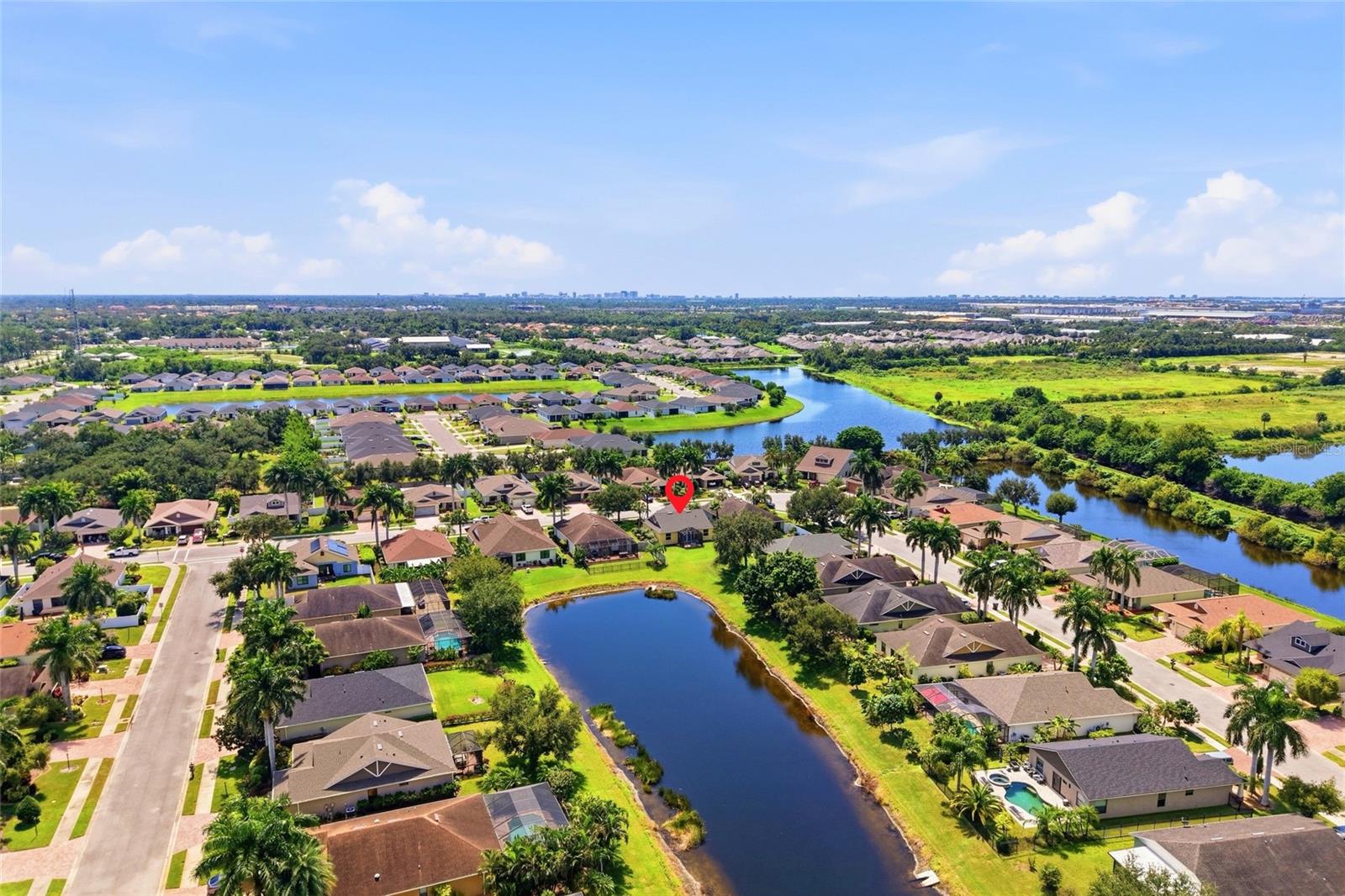 Aerial view of a marked home in a neighborhood with ponds and winding waterways.