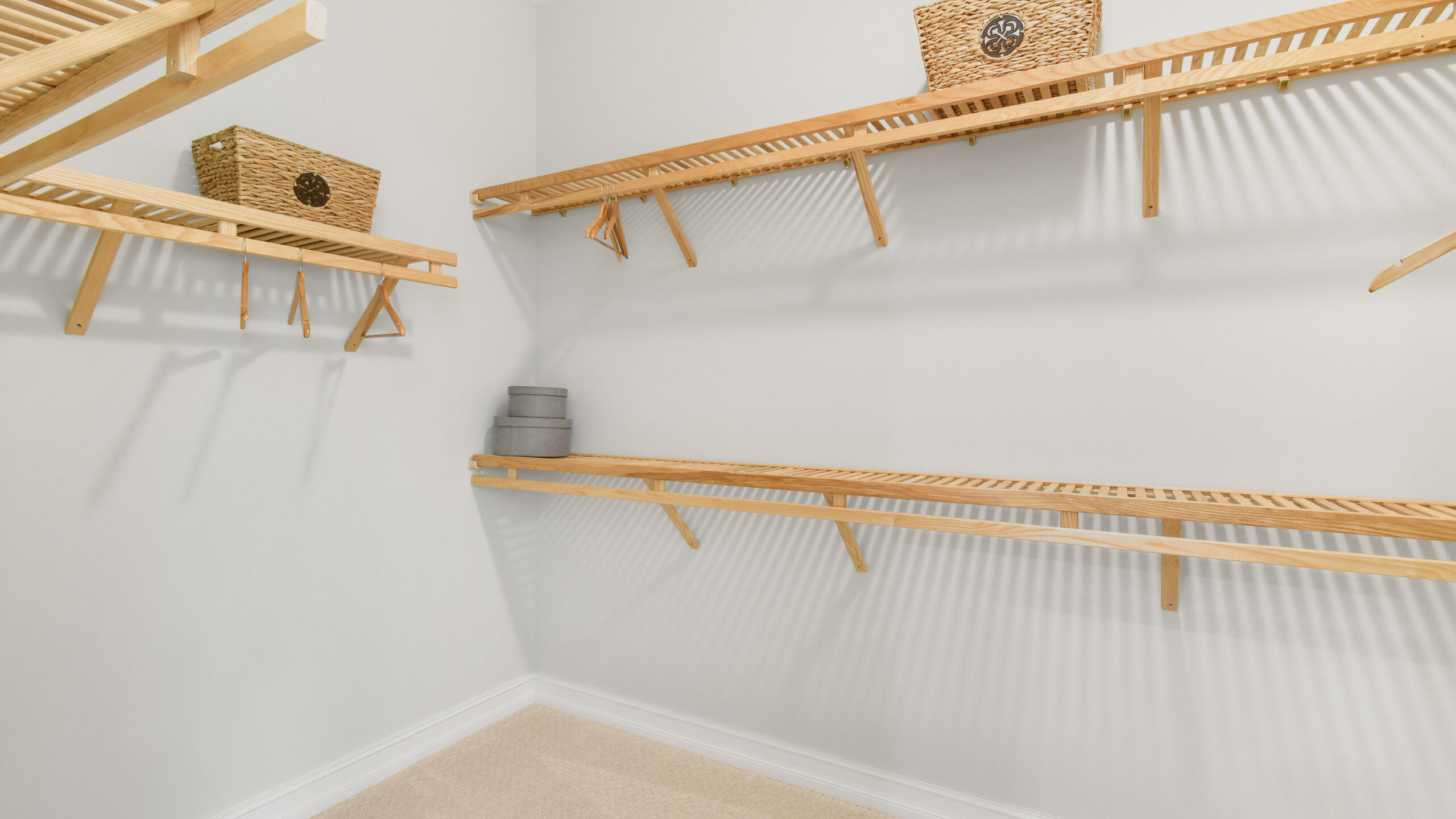 Walk-in closet with extensive natural wood shelving and hanging rails