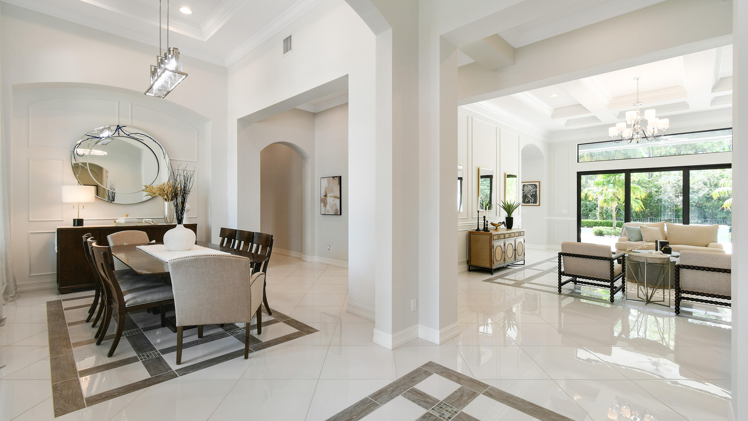 Open-plan dining and living room with glossy tile floors and large windows overlooking greenery.