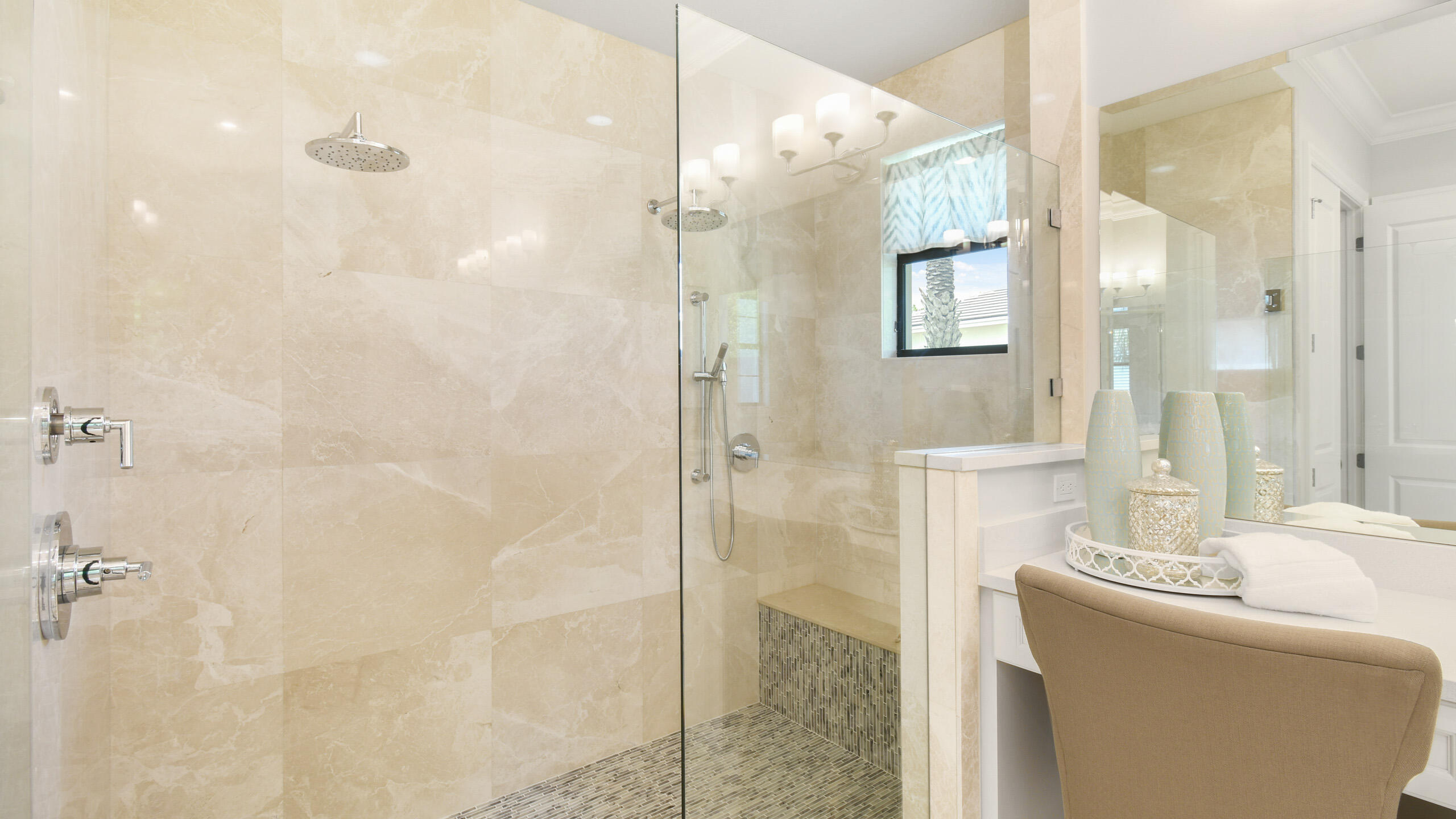 Bathroom with a glass walk-in shower, beige stone tile, mosaic floor, and built-in bench.