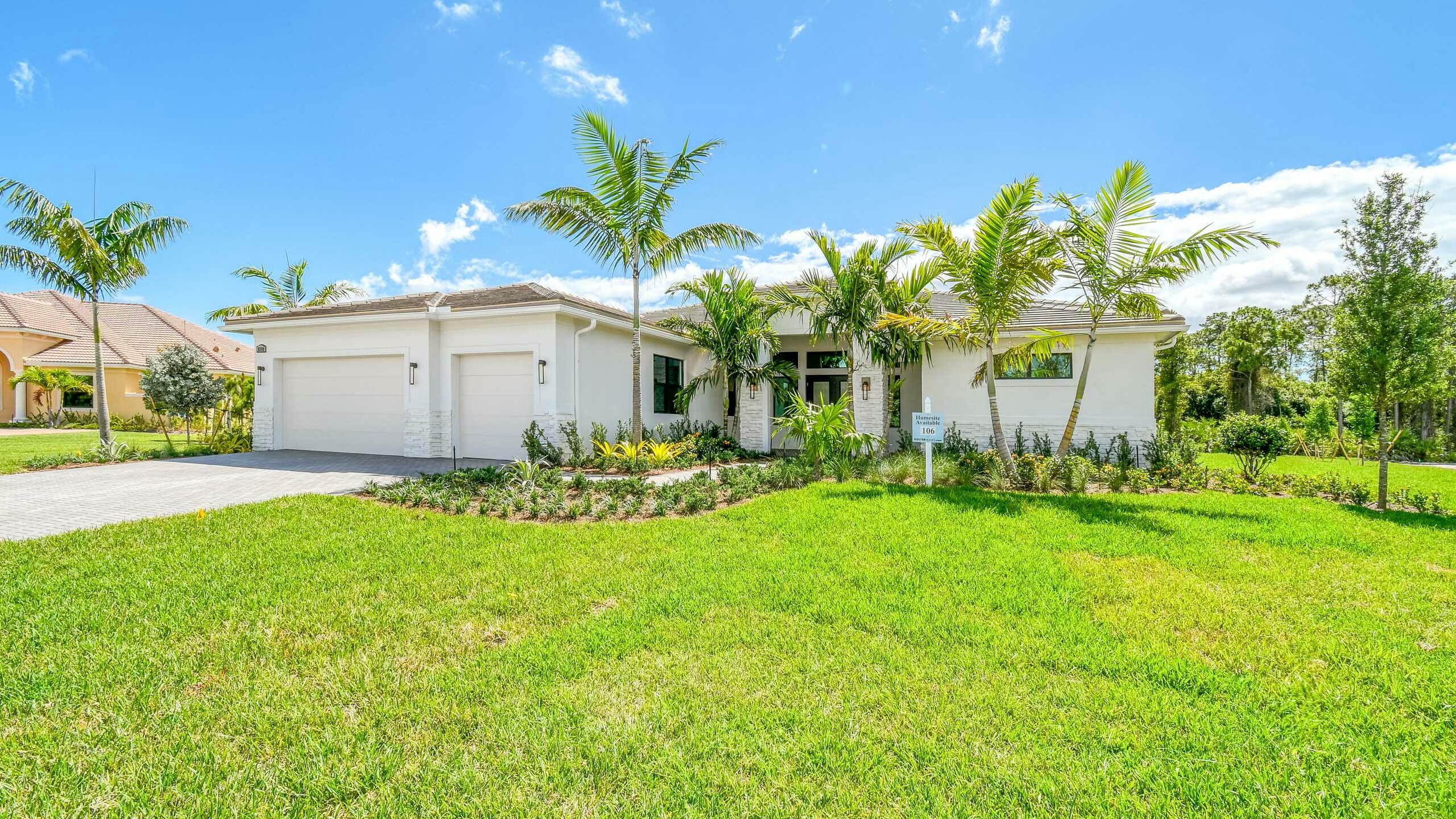 White single-story home with a two-car garage, palm landscaping, and a broad front lawn.