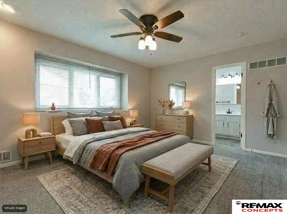 Virtually staged bedroom with a large bed, light-wood furniture, and a ceiling fan.