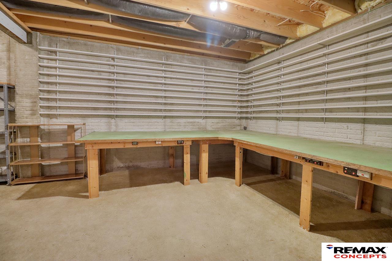 Basement workshop with built-in workbenches and extensive wall shelving.