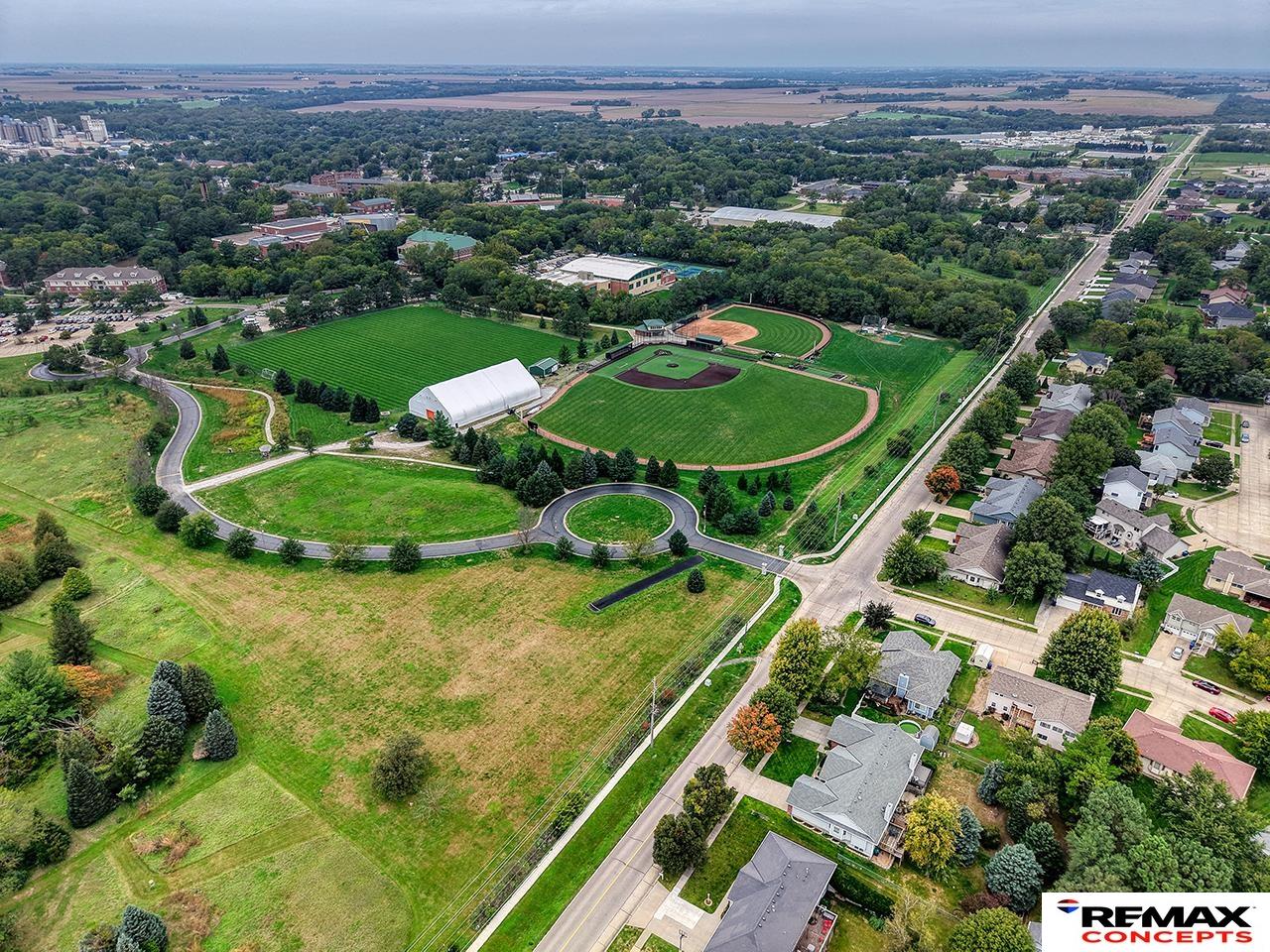 Aerial view of a neighborhood beside baseball fields and a broad expanse of green lawns.