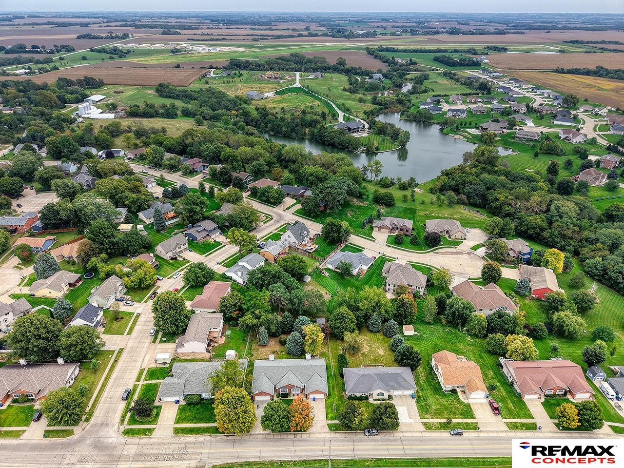 Aerial view of homes around a pond, with farmland stretching across the horizon.