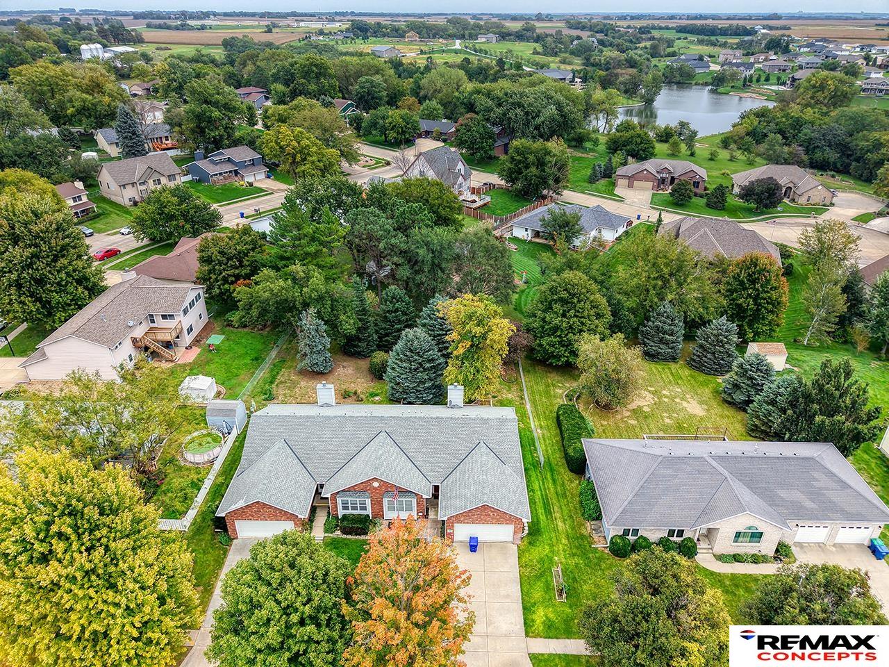Aerial view of homes among mature trees, with a lake visible in the distance.