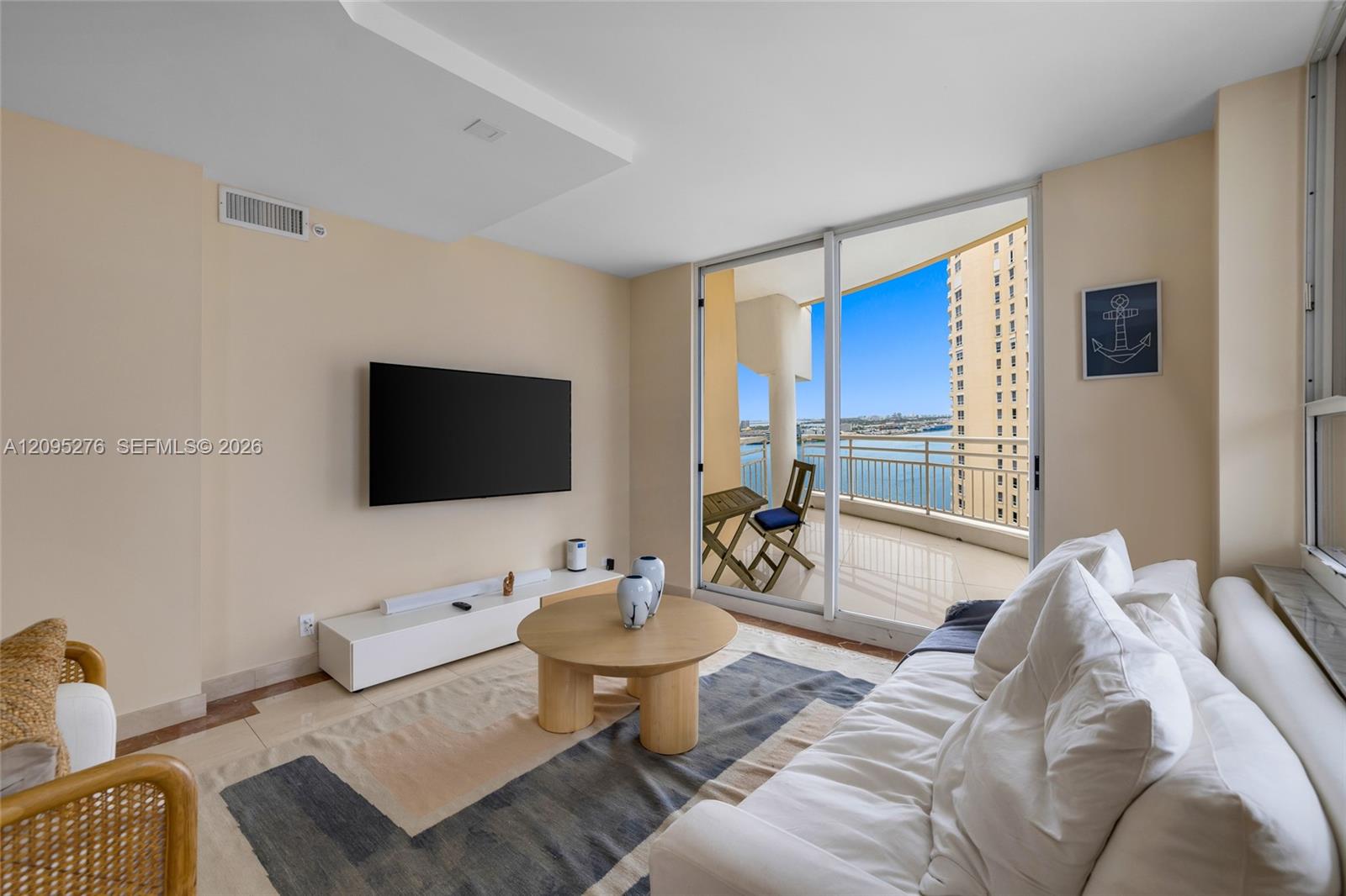 Living room with a white sectional and a balcony overlooking the water.