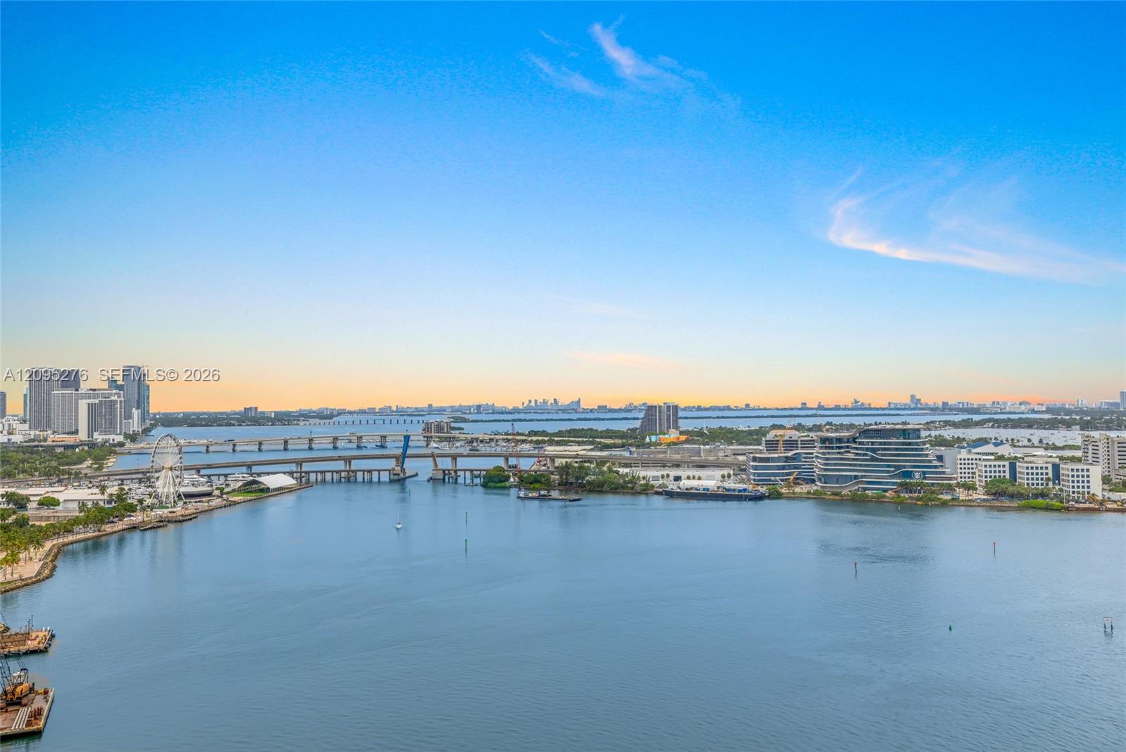 Waterfront view toward Miami’s skyline, with bridges and a Ferris wheel.