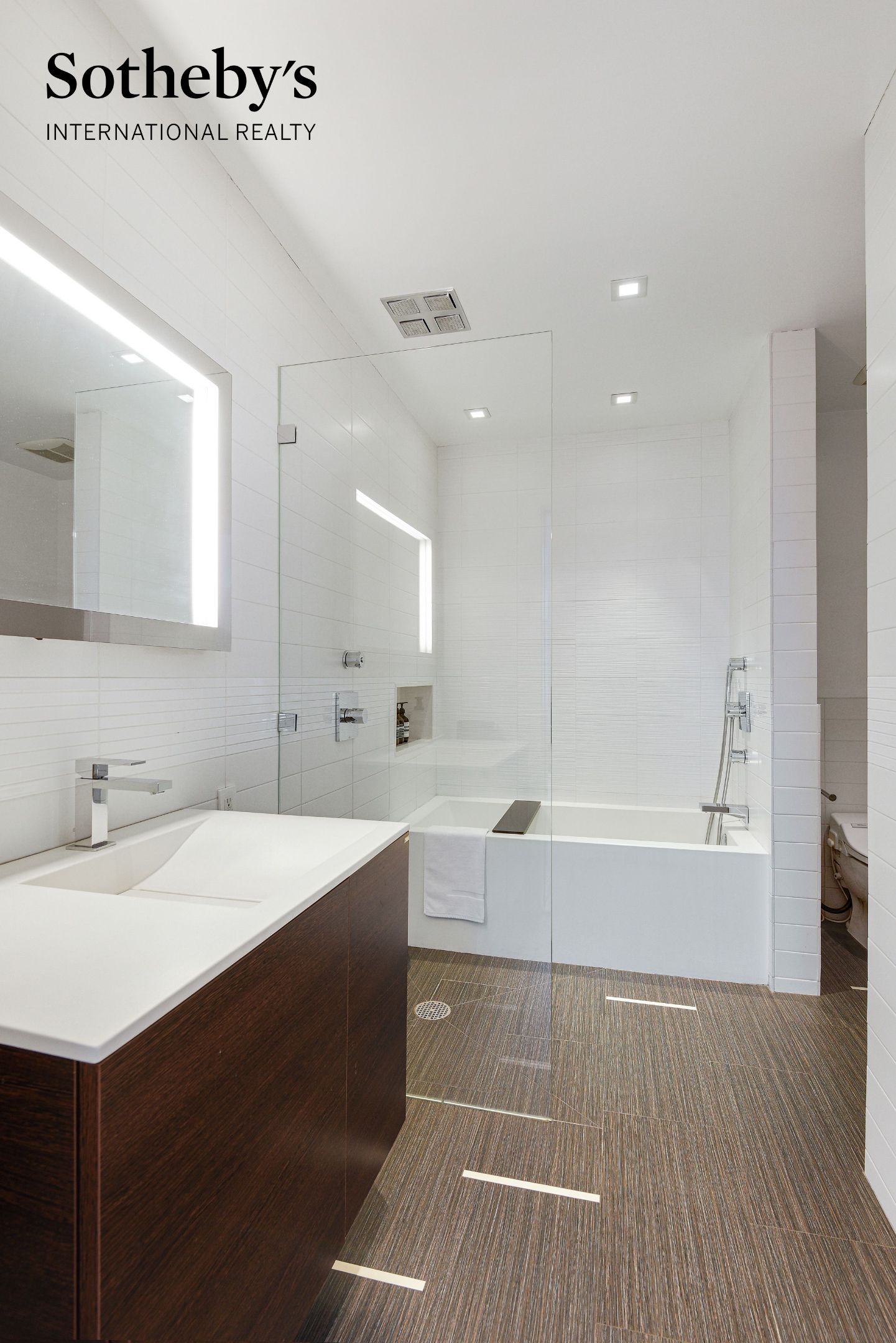 Bathroom with a dark wood vanity, glass-enclosed tub and shower, and white tile.