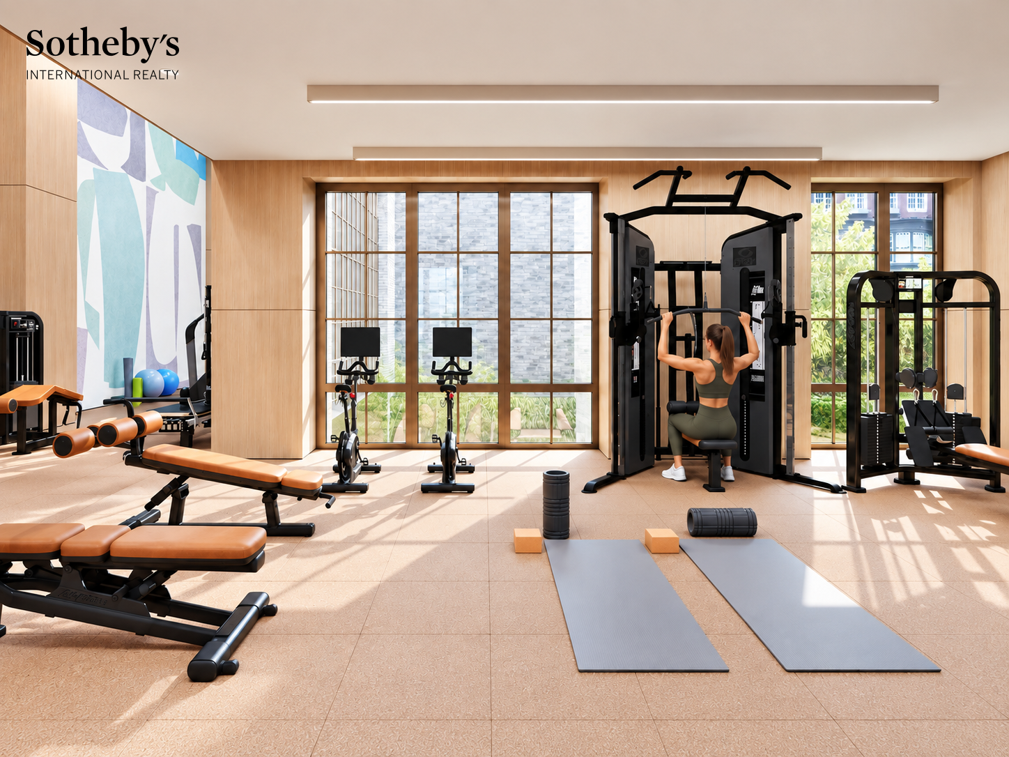 Residential fitness center with workout equipment, yoga mats, and a woman using a weight machine.