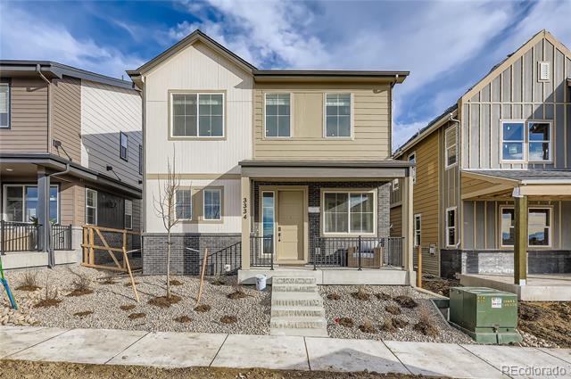 Two-story beige house with a covered porch and gravel front yard, flanked by neighboring homes.