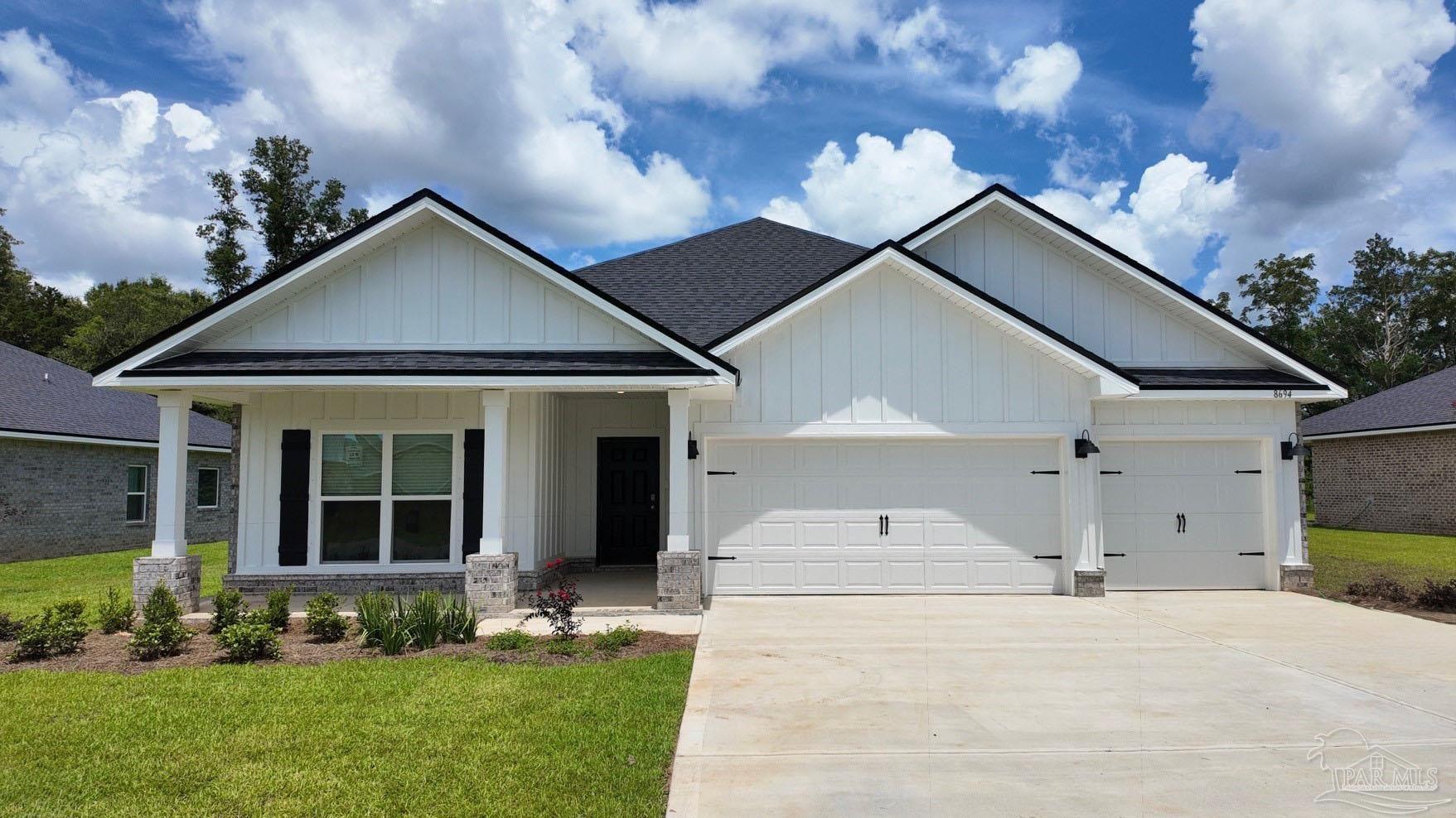 White single-story home with a covered porch, three-car garage, and broad concrete driveway.