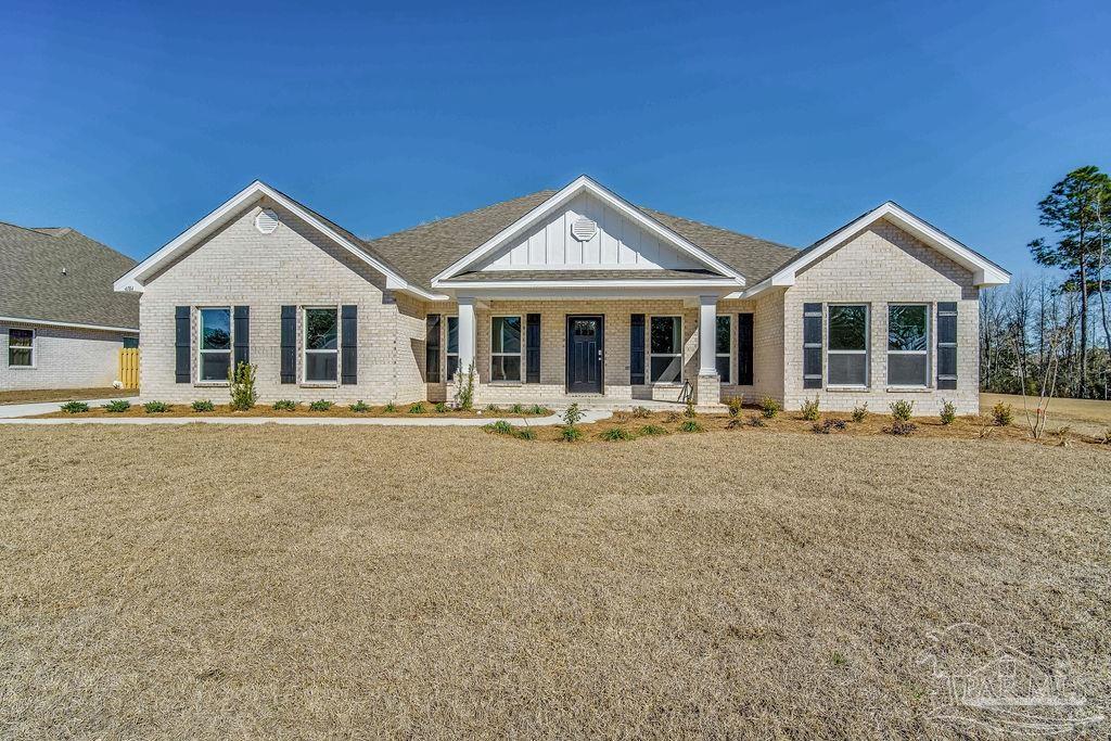 Single-story brick house with three front gables, dark shutters, and a broad front lawn.
