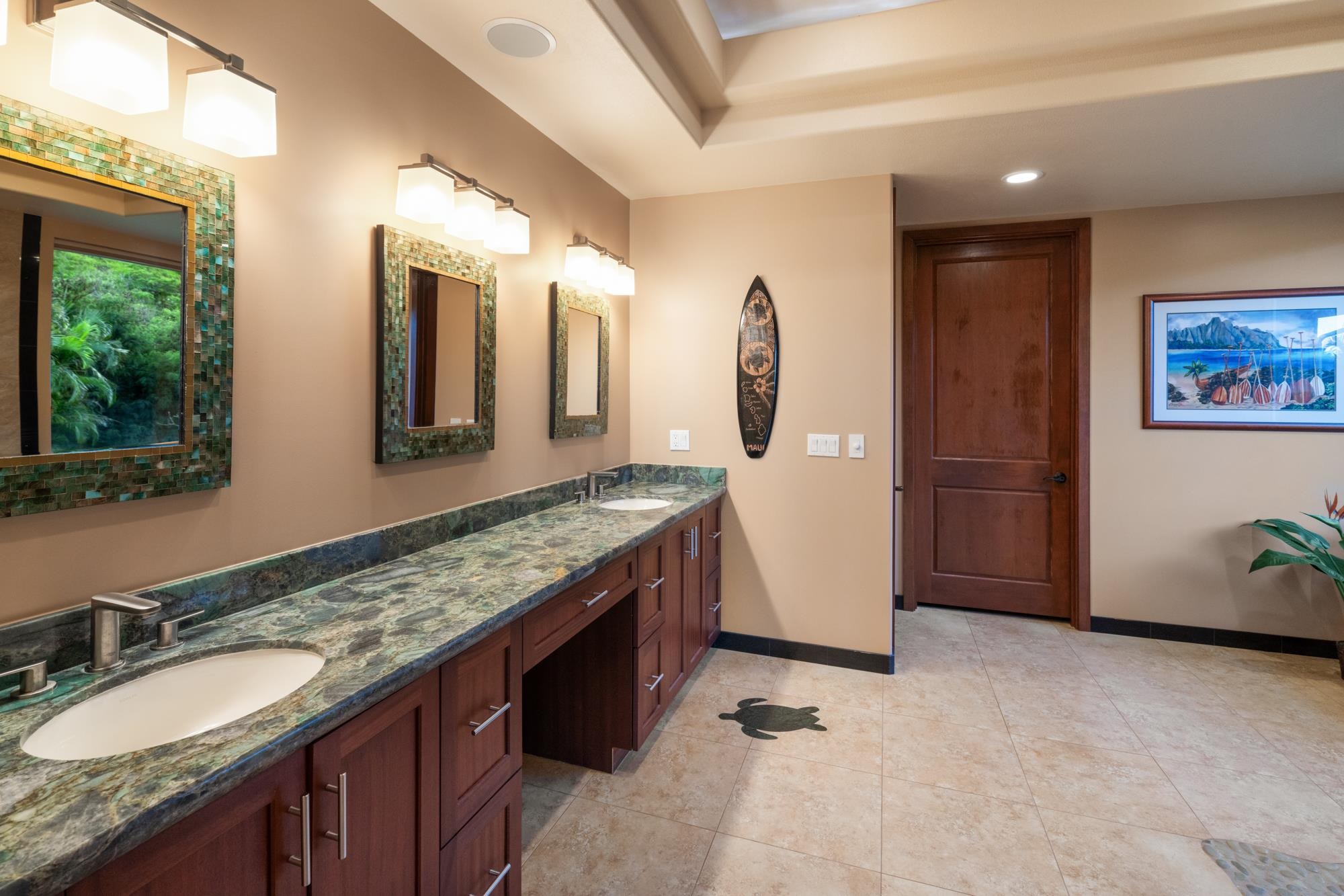 Bathroom with a long green stone double-sink vanity, mosaic-framed mirrors, and dark wood cabinetry.