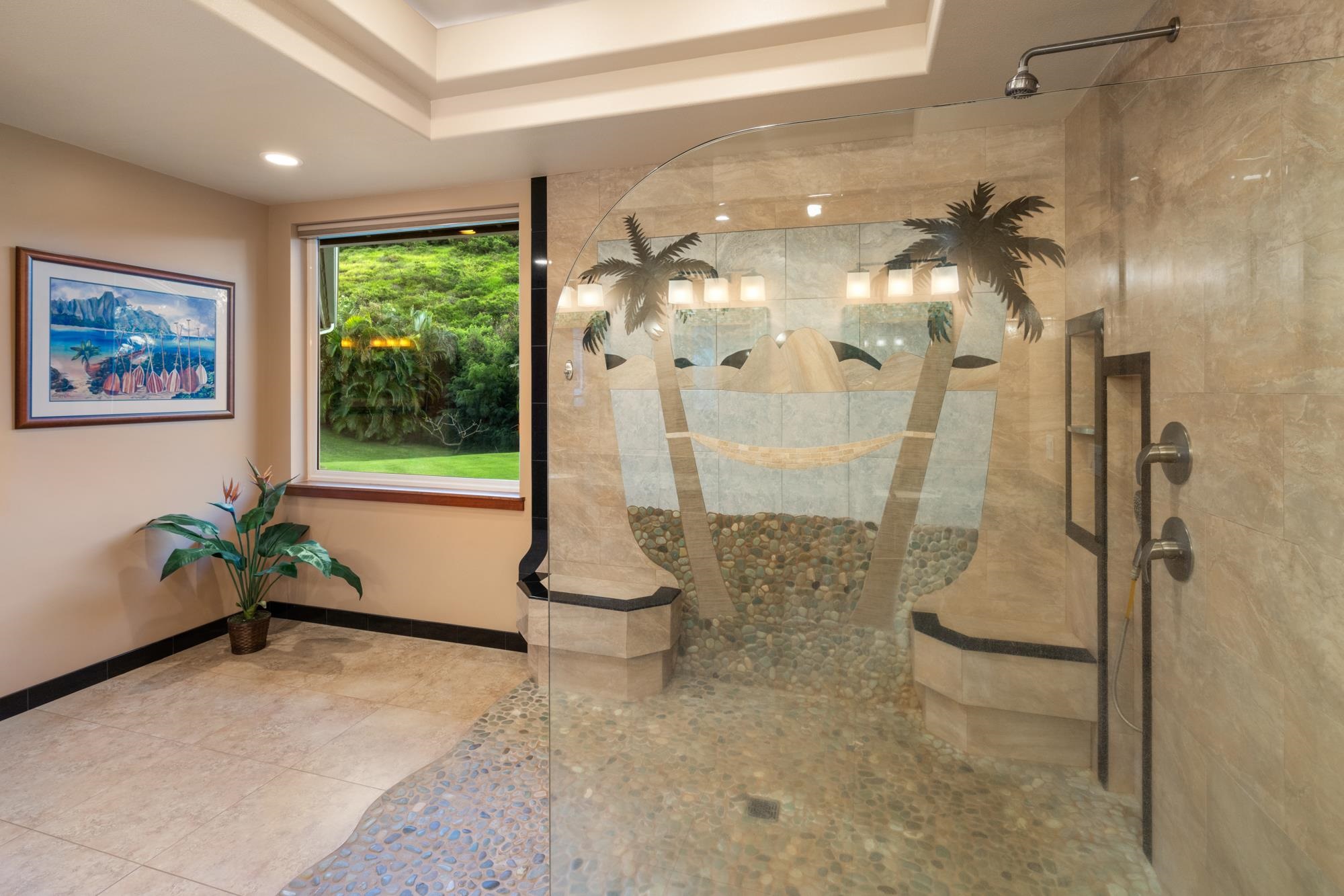 Bathroom with a curved-glass walk-in shower, pebble floor, and palm-tree tile mosaic.