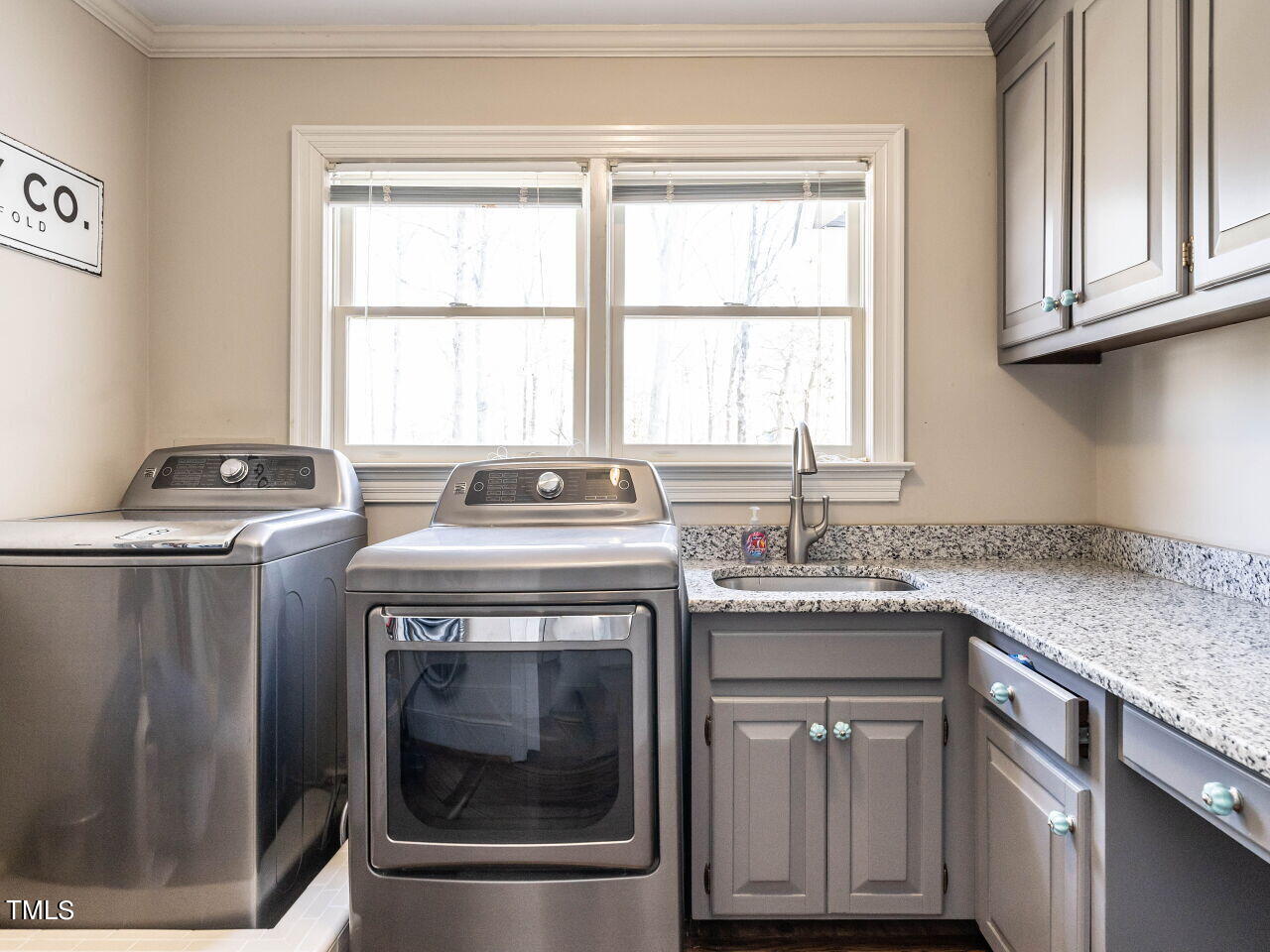 Laundry room with washer and dryer, granite counter, utility sink, and gray cabinets.