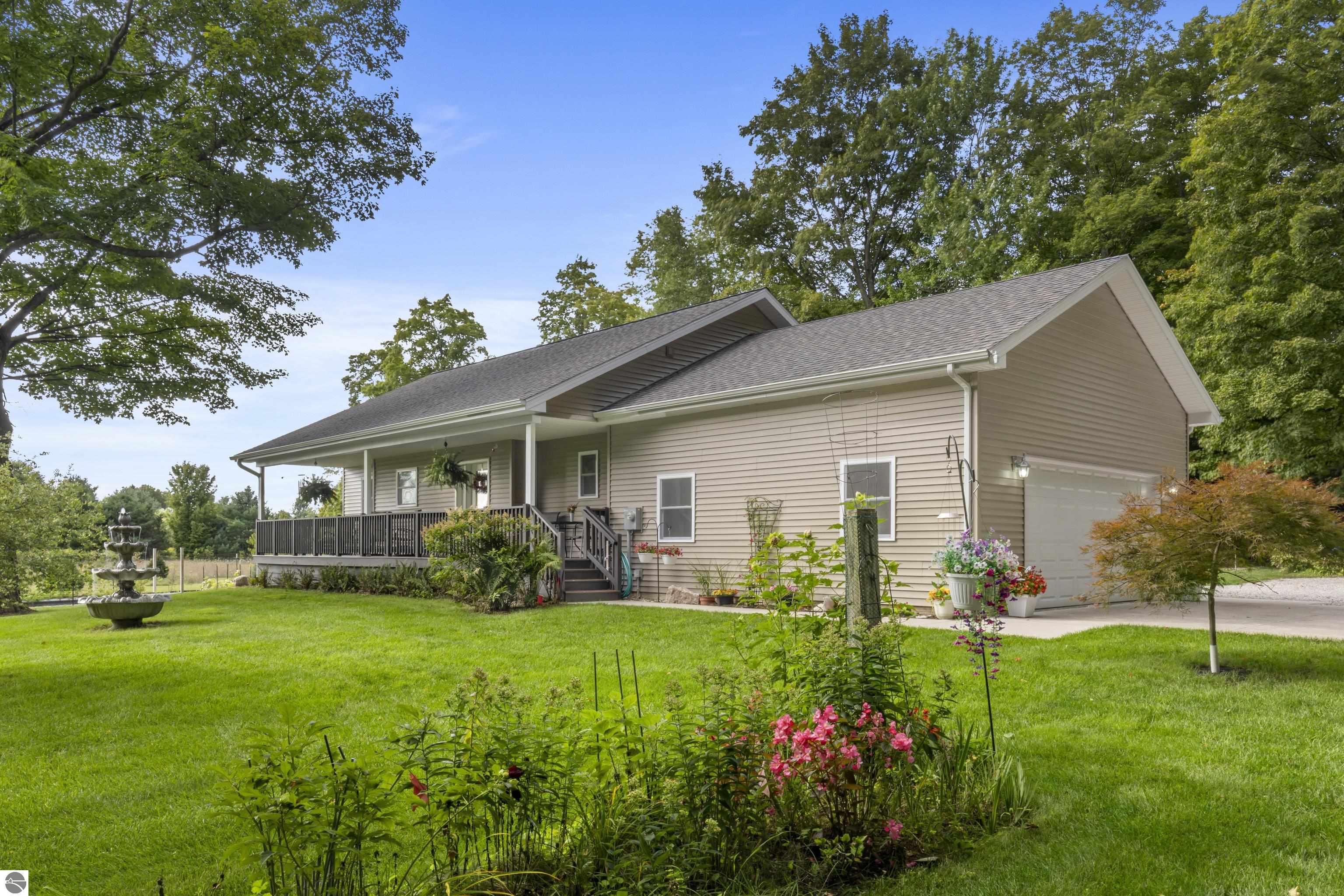 7686 Indian Hill Road home with a covered porch, attached garage, and landscaped lawn.