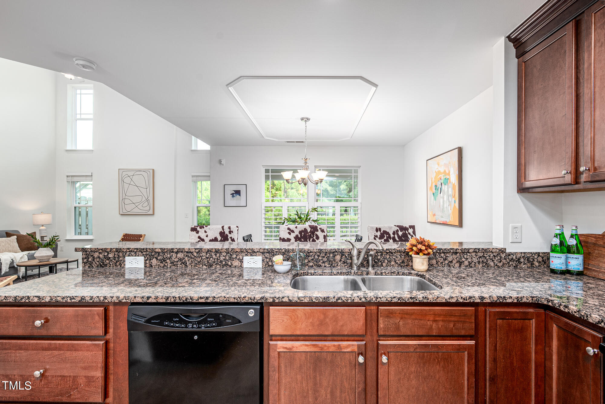 Kitchen with speckled granite counters, reddish wood cabinets, and a double-basin sink.