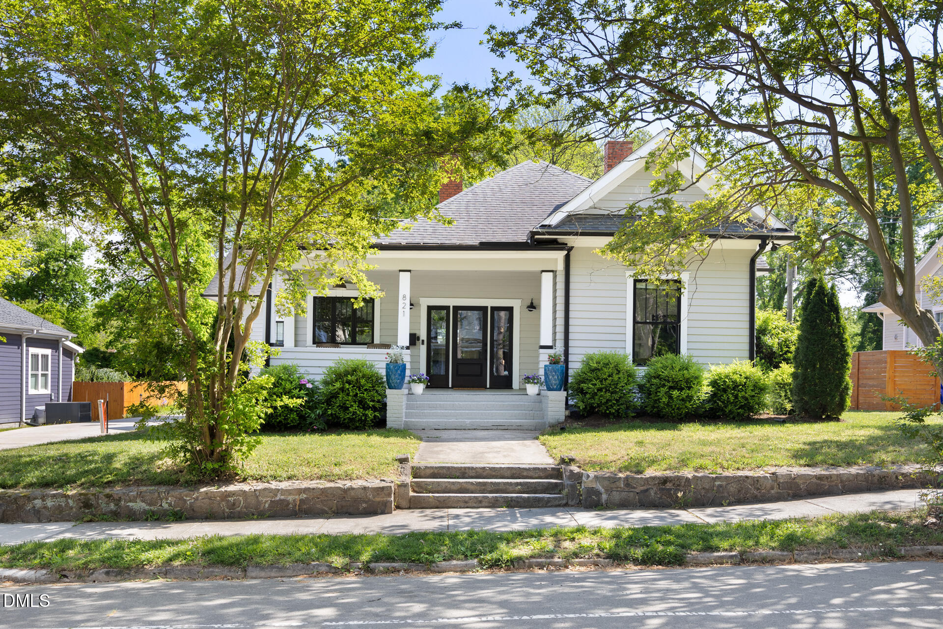 White-sided house with a covered porch and mature trees at 821 Wilkerson Avenue.