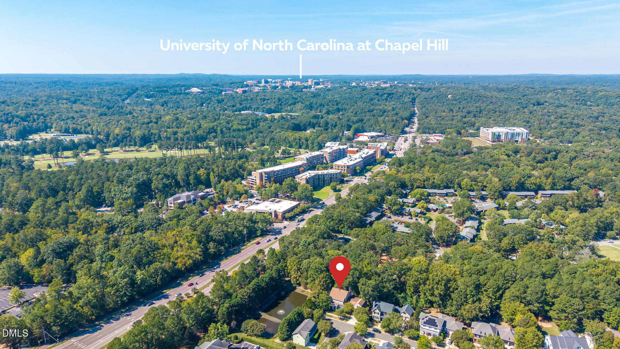 Aerial view of a Chapel Hill home marked by a red pin, with UNC Chapel Hill in the distance.