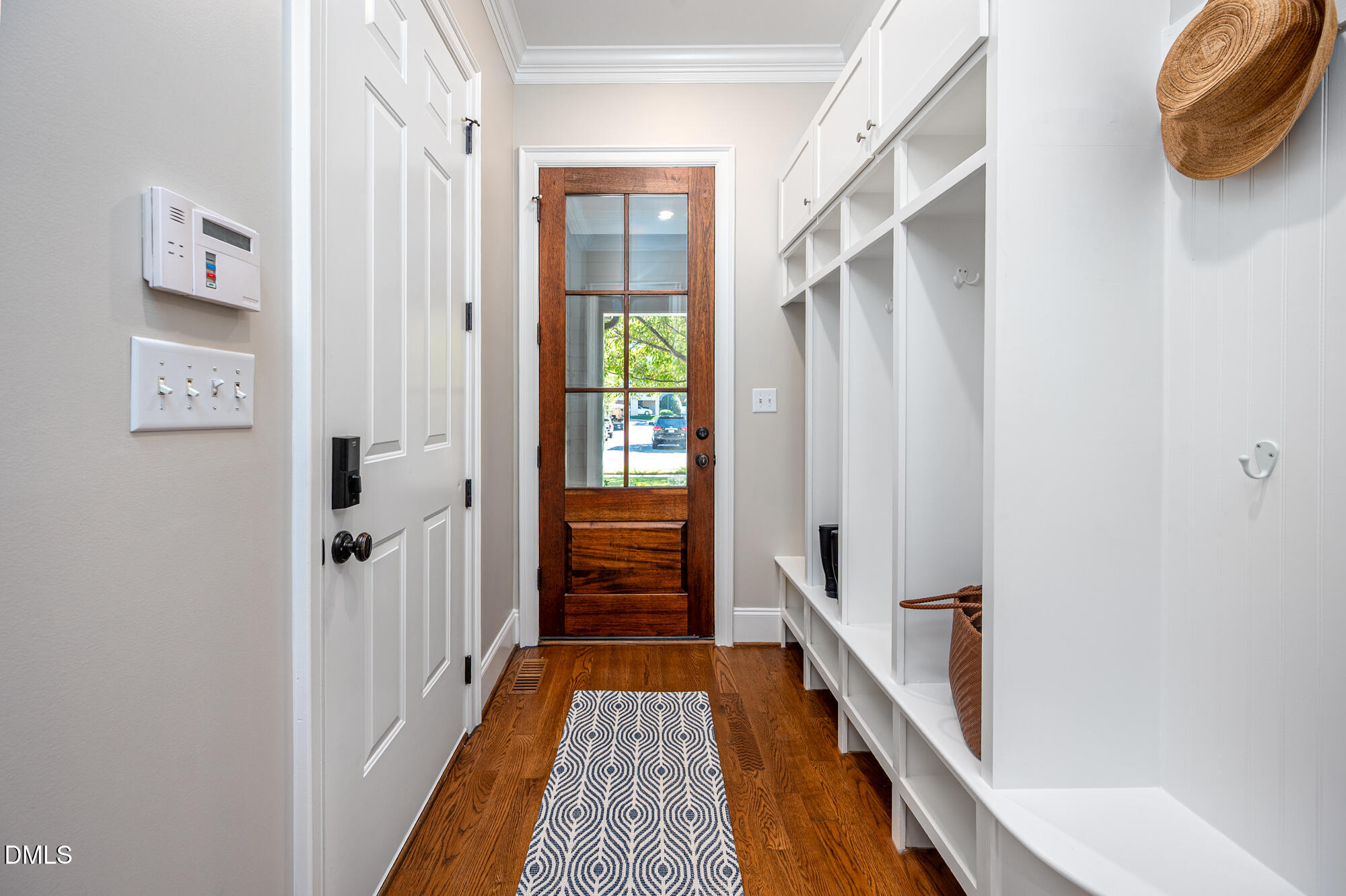 Entryway with a glass-paneled wood front door and white built-in cubbies.
