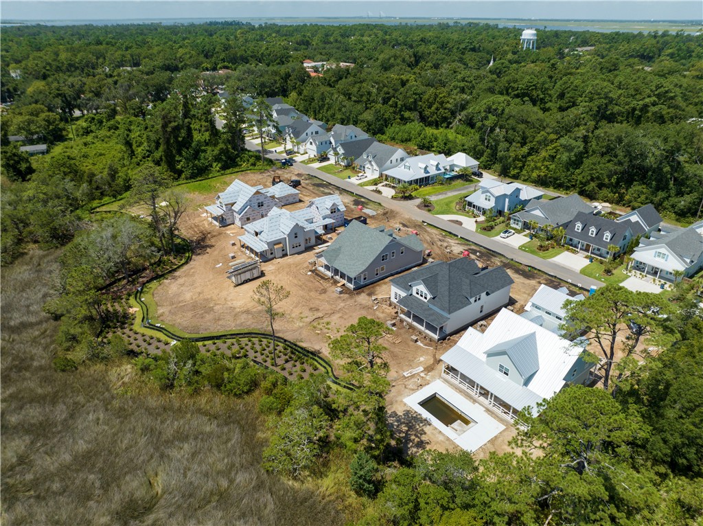 Aerial view of a coastal neighborhood with homes under construction beside marshland.