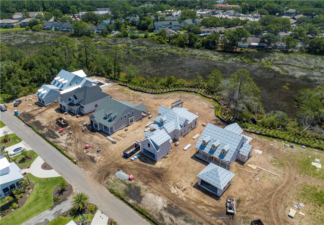 Aerial view of homes under construction beside a marsh and residential neighborhood.