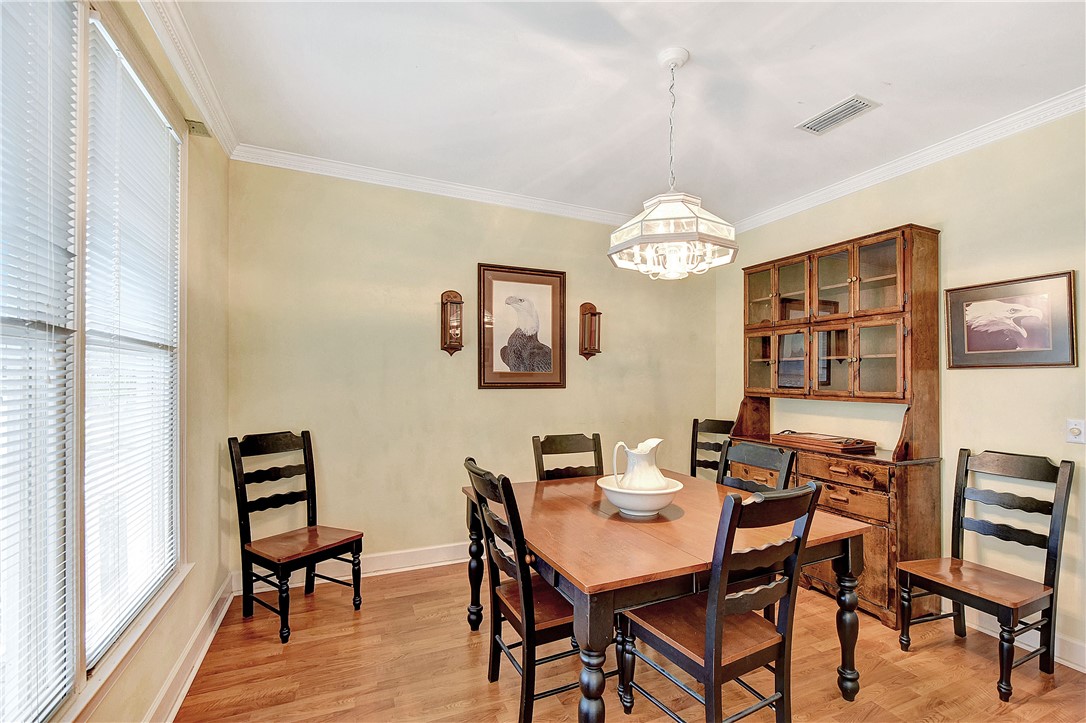 Dining room with a wooden table, dark chairs, glass-front china cabinet, and chandelier.