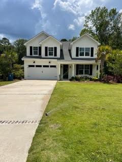 Two-story house with twin front gables, an attached garage, and a wide concrete driveway.
