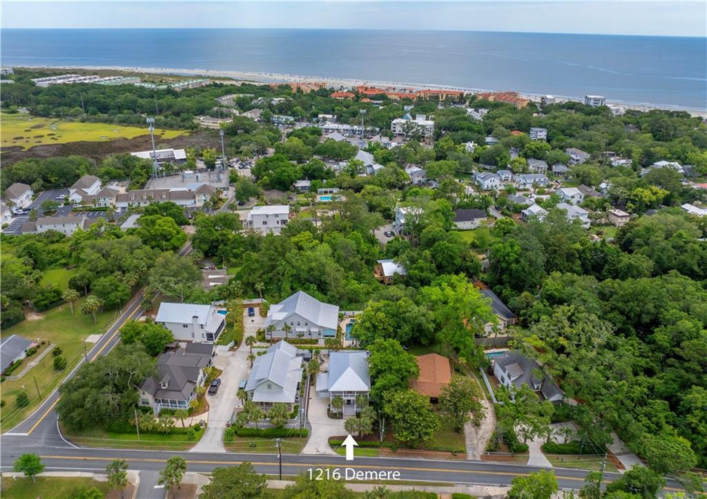 Aerial view of the marked 1216 Demere Road home, with a leafy neighborhood and ocean beyond.