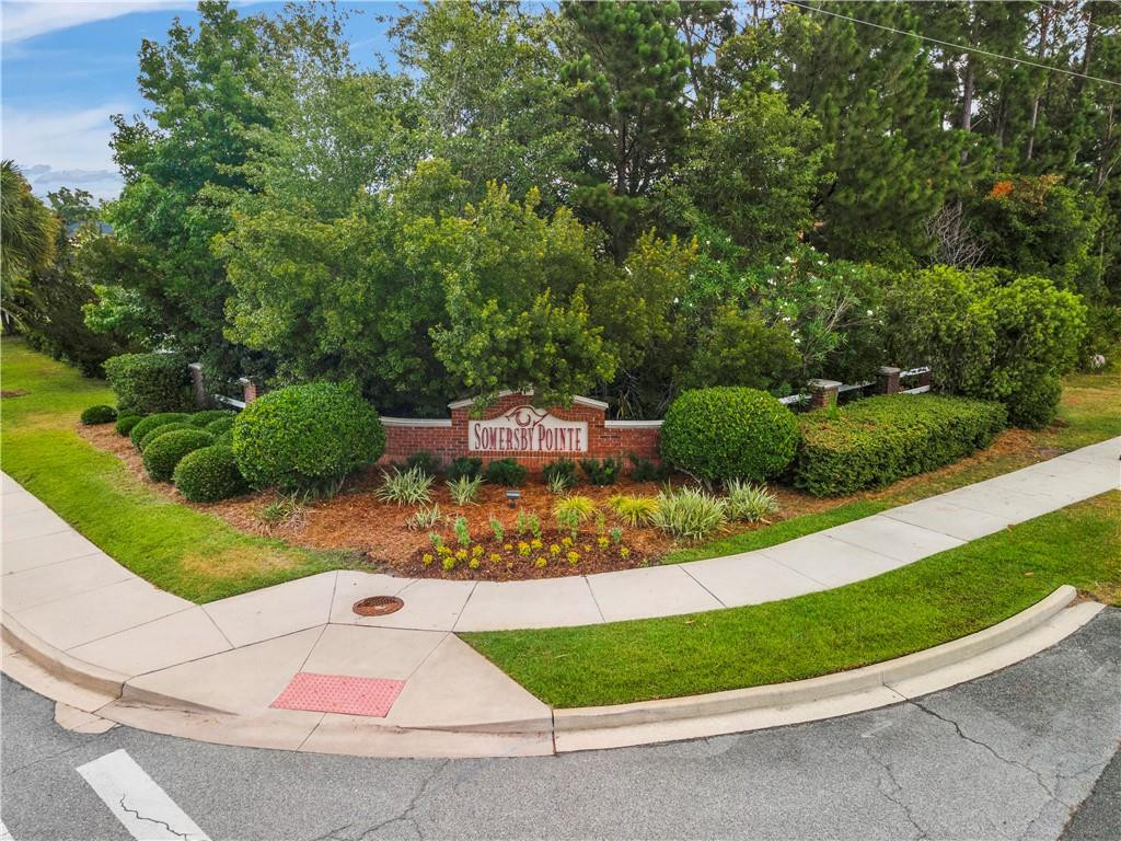 Somersby Pointe entrance sign amid landscaping beside a curved sidewalk.