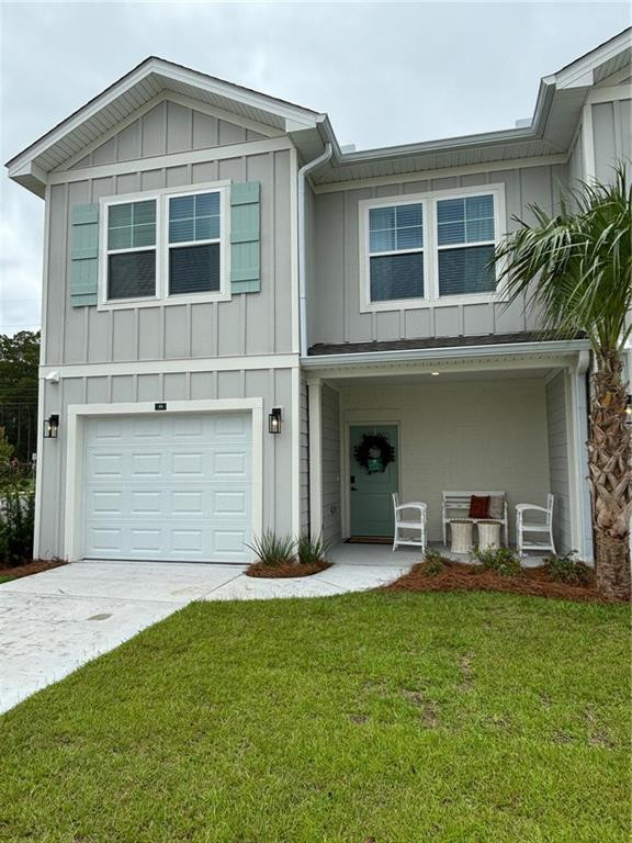 Two-story gray home with a white garage door, covered porch, and palm tree beside the lawn.