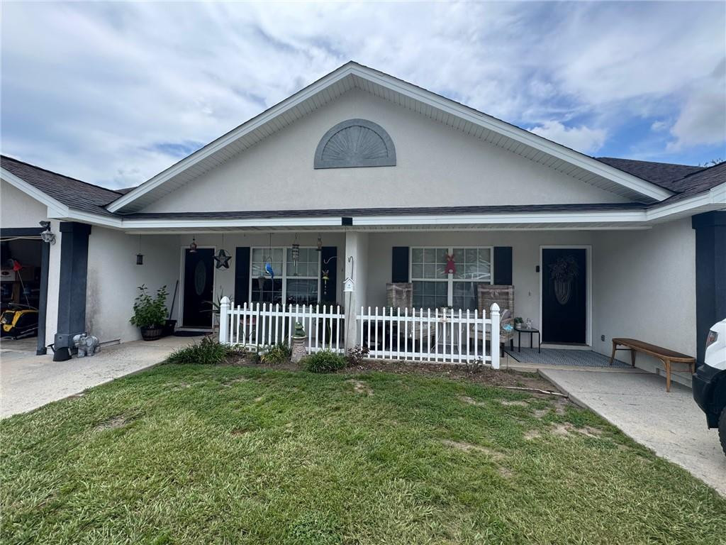 Single-story home with two entry doors, a white-fenced porch, and a carport.