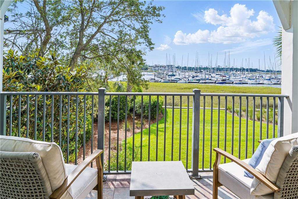 Furnished balcony overlooking a marina filled with sailboats.