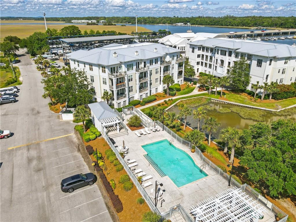 Waterfront condominium complex with a swimming pool, marina, and marsh views.