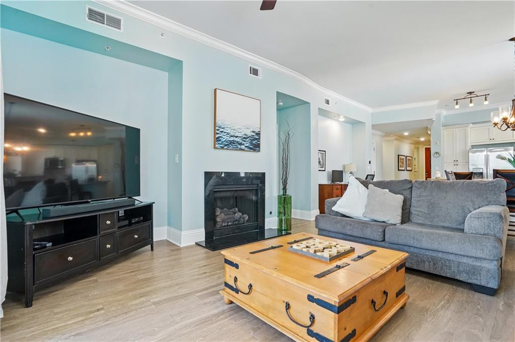 Living room with a gray sectional, black fireplace, and wooden trunk coffee table.