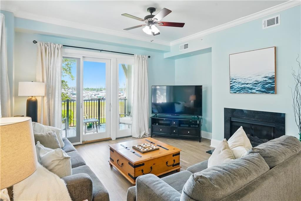 Living room with gray sofas and a balcony overlooking a marina.