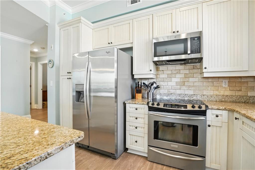 Kitchen with white cabinets, stainless steel appliances, and granite countertops.