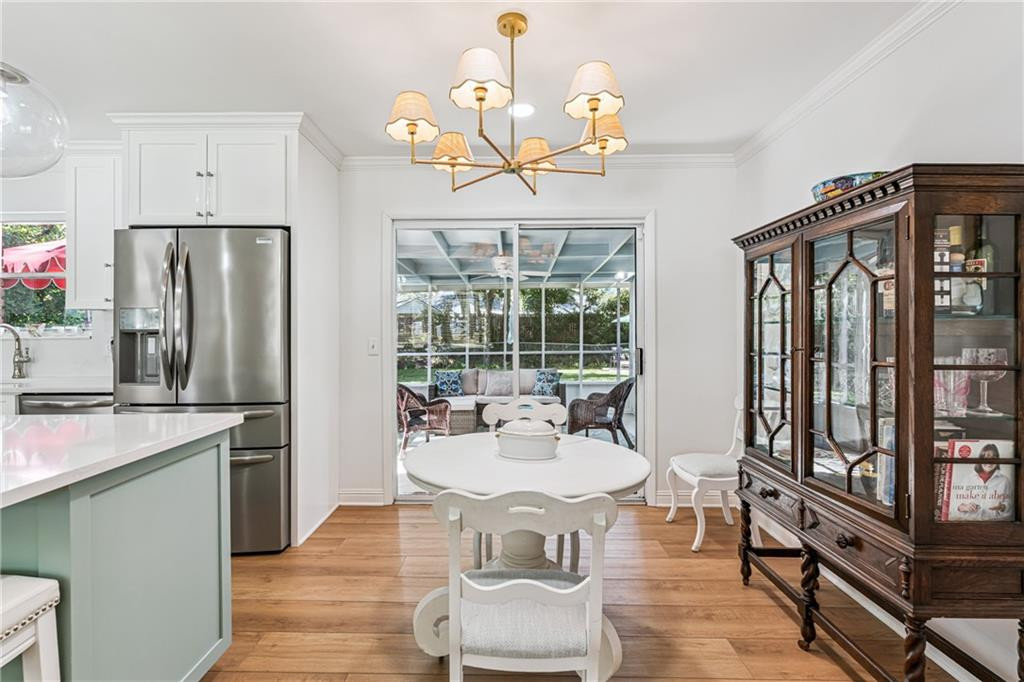 Dining room with a round white table, glass-front china cabinet, and sliding doors to a covered patio.