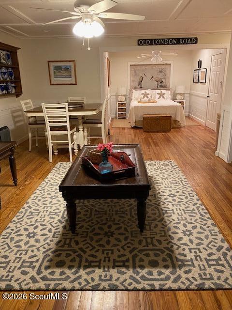 Bedroom with a recessed bed alcove, dining table, and dark coffee table on a patterned rug.