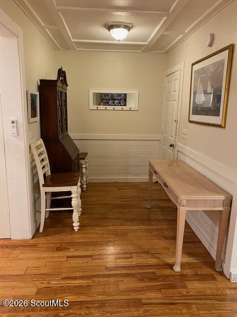 Hallway with polished hardwood floors, white wainscoting, and a long console table.
