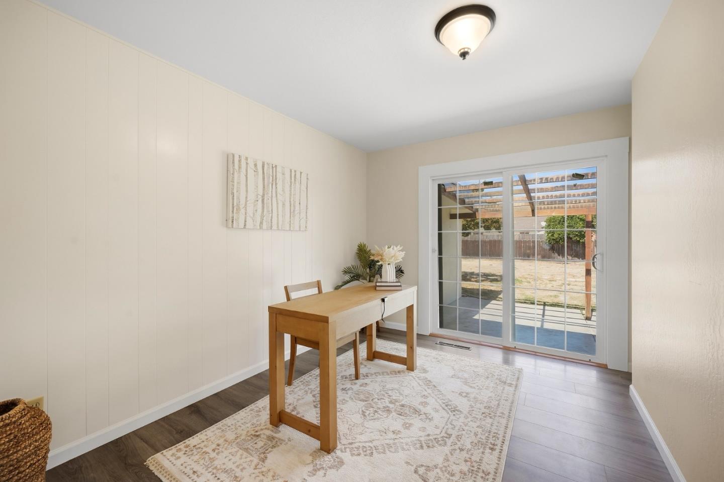 Dining area with a wood table and sliding glass doors opening to a covered patio.