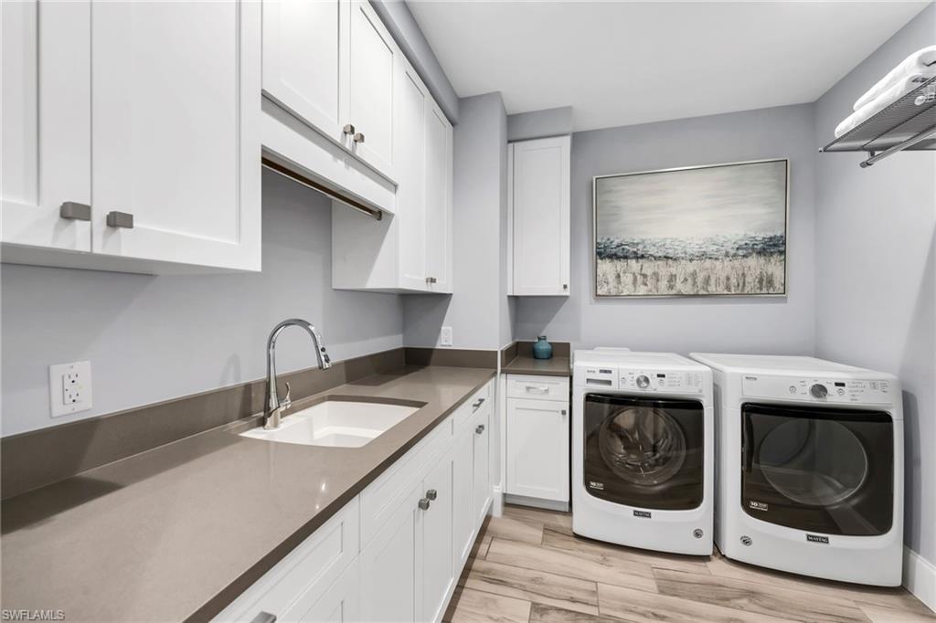 Laundry room with white cabinetry, a utility sink, and front-loading washer and dryer.