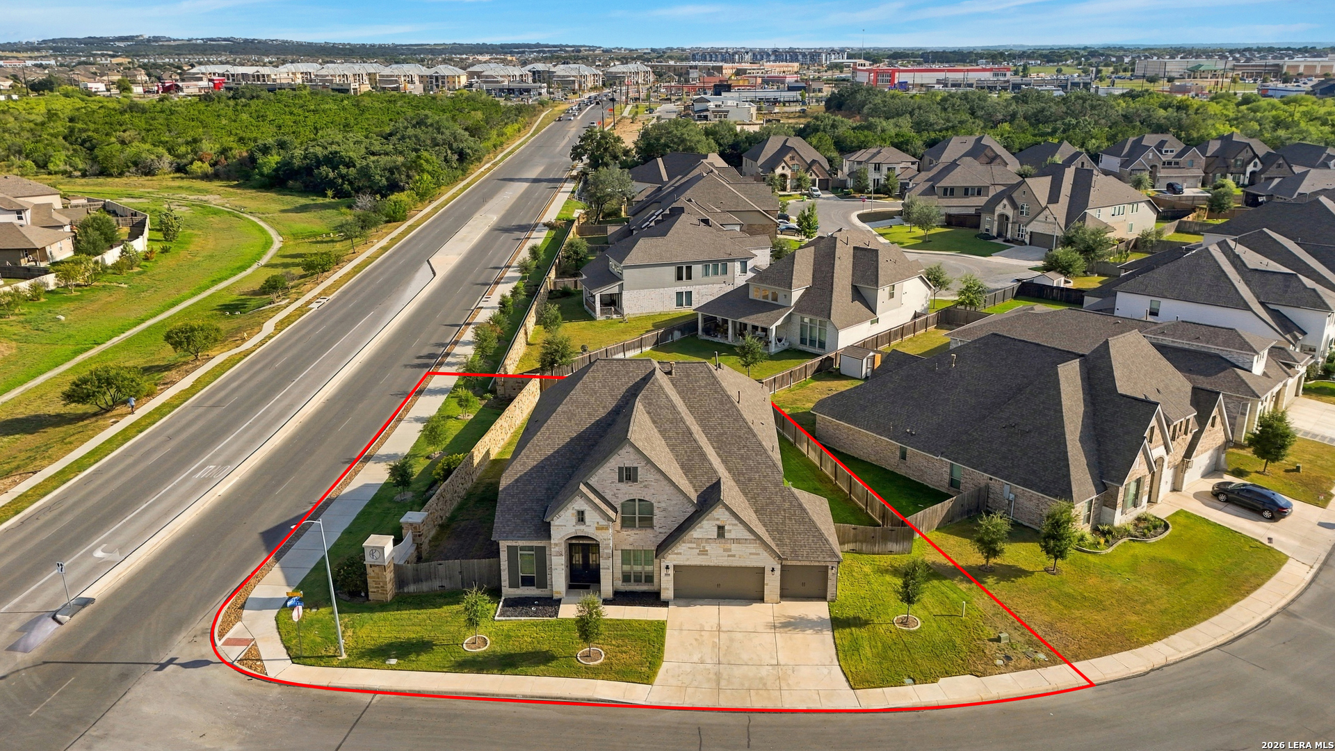 Stone two-story corner home with an attached garage, outlined in red from above.