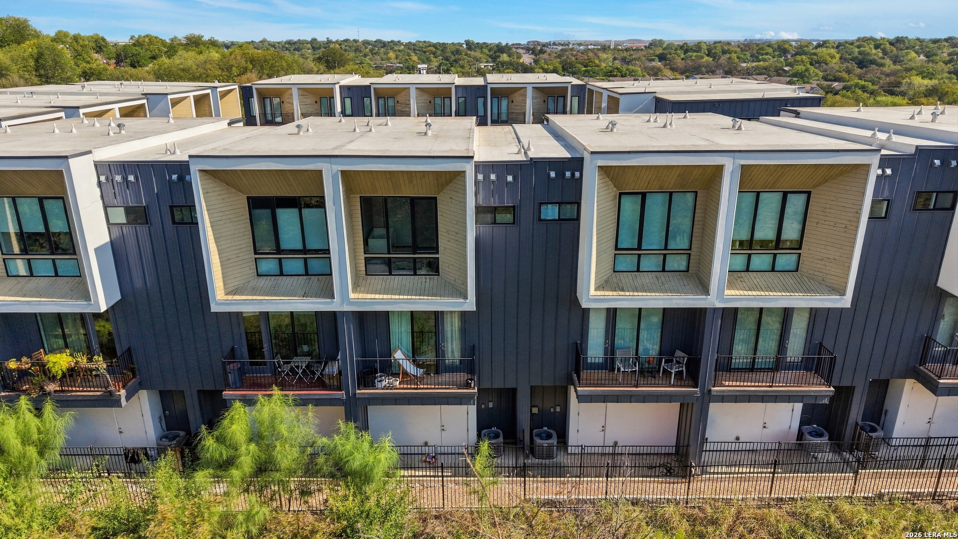 Aerial view of modern townhomes with projecting windows and private balconies.