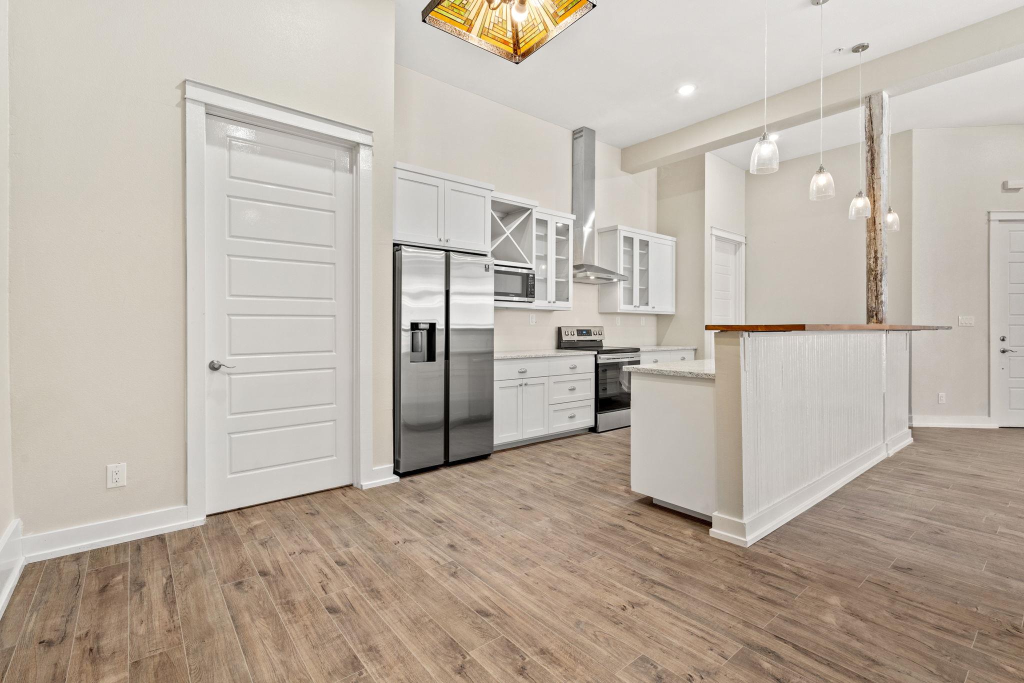 Kitchen with white cabinets, stainless steel appliances, and a wood-topped peninsula.